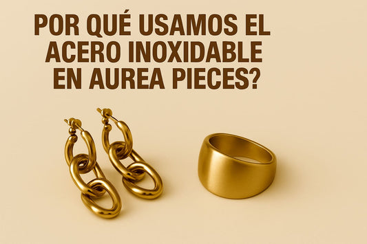 Banner con el texto “Por qué usamos acero inoxidable en Aurea Pieces” sobre fondo claro, acompañado de collares y anillos de acero inoxidable.