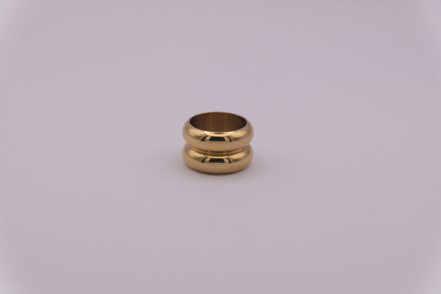 Anillo dorado con textura ondulada "The Morning Flow" sobre fondo blanco.