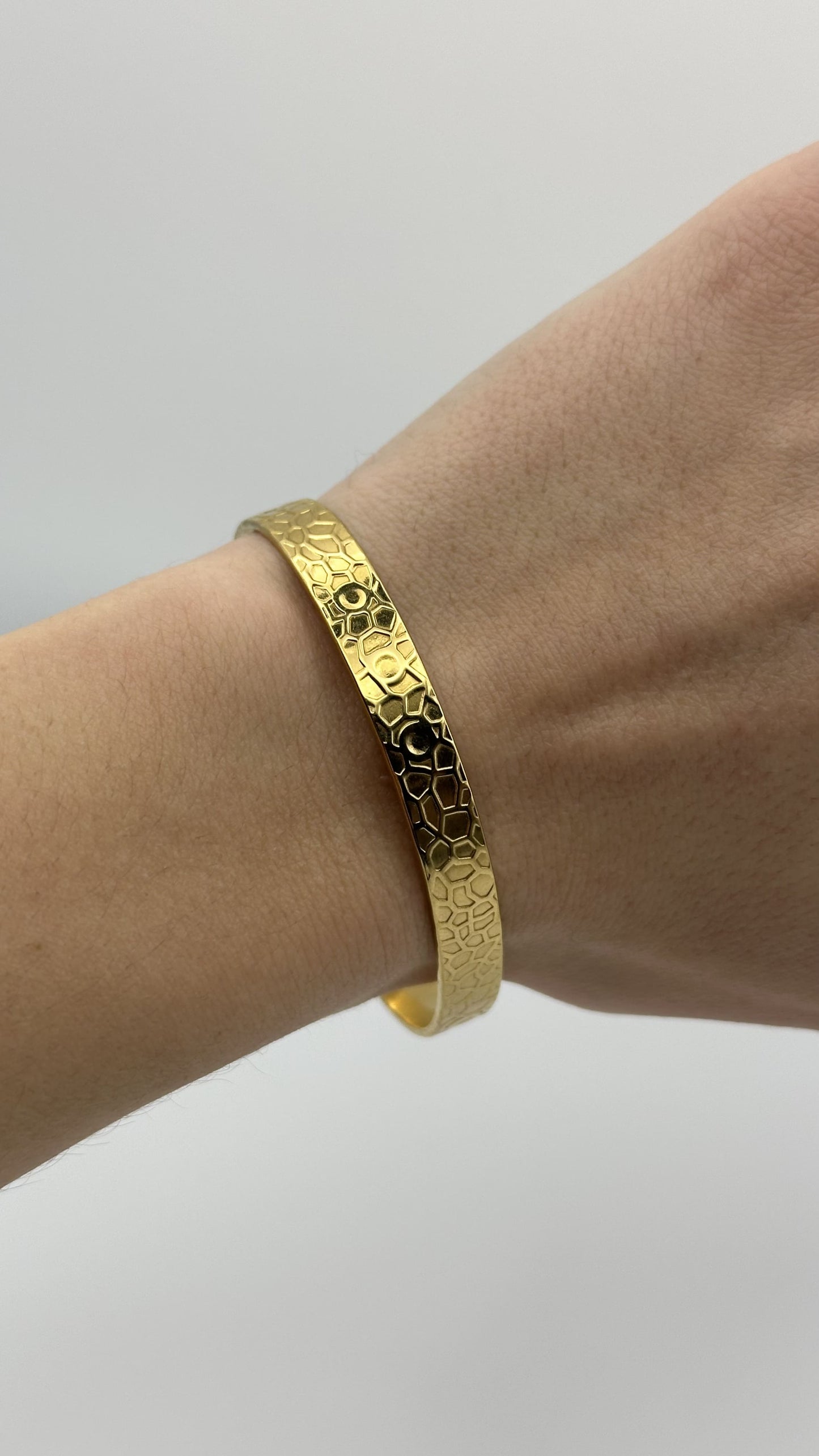 Detalle del diseño fluido de la pulsera "The Bubble Bliss" en mano de modelo.