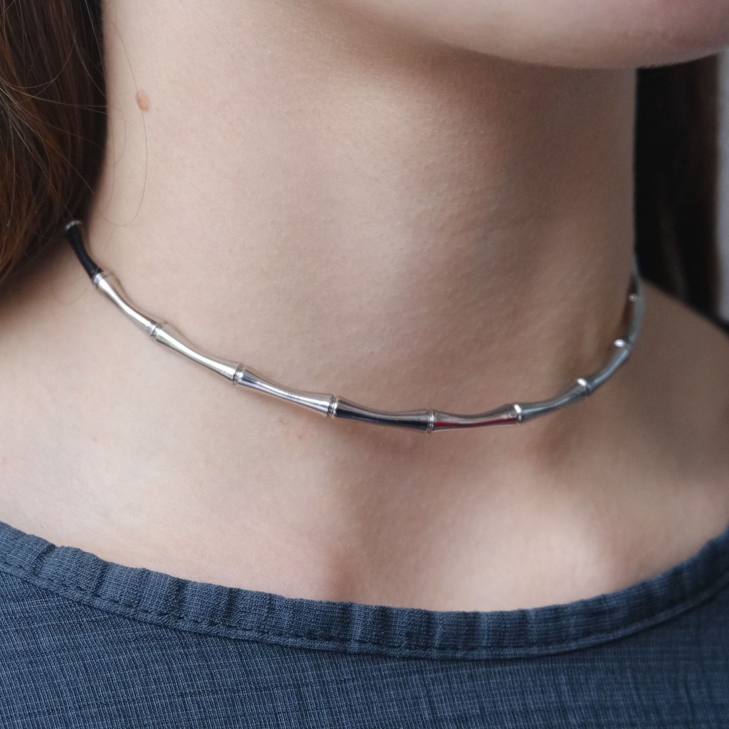 Vista lateral del collar plateado "The Glow Chain" mostrando su acabado pulido.