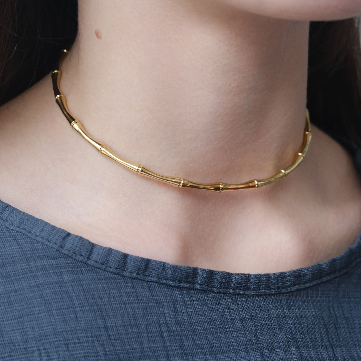 Collar dorado "The Glow Chain" lucido por una modelo.