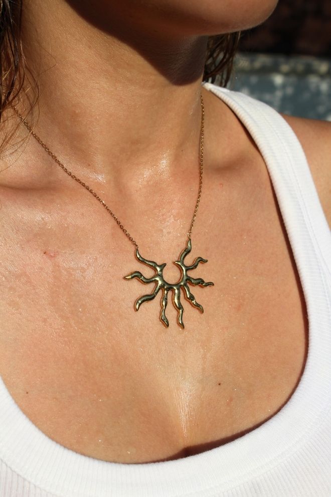 Mujer luciendo el Collar Sol Caribeño en el cuello, con fondo soleado y piel húmeda.