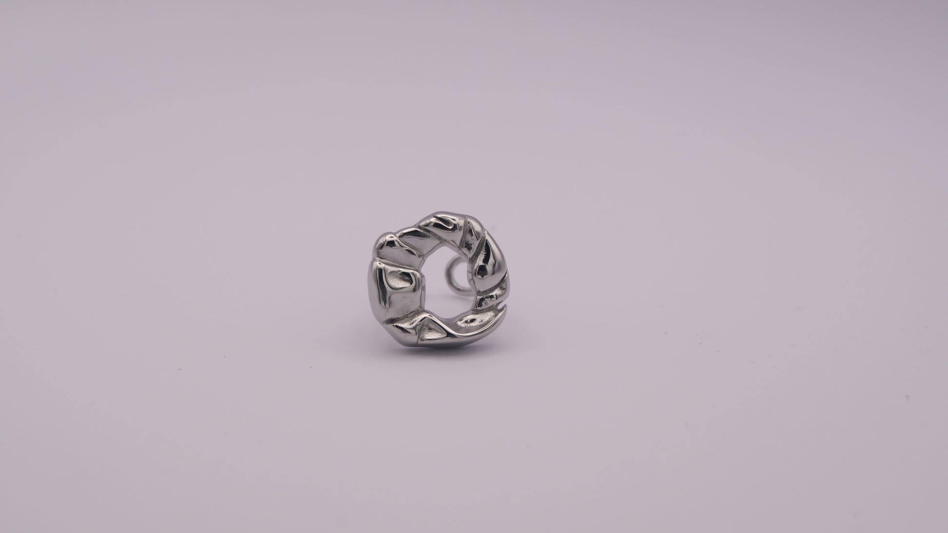 Anillo plateado con textura orgánica "The Cozy Pop" sobre fondo blanco.