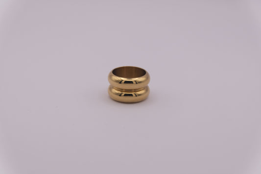 Anillo dorado con textura ondulada "The Morning Flow" sobre fondo blanco.