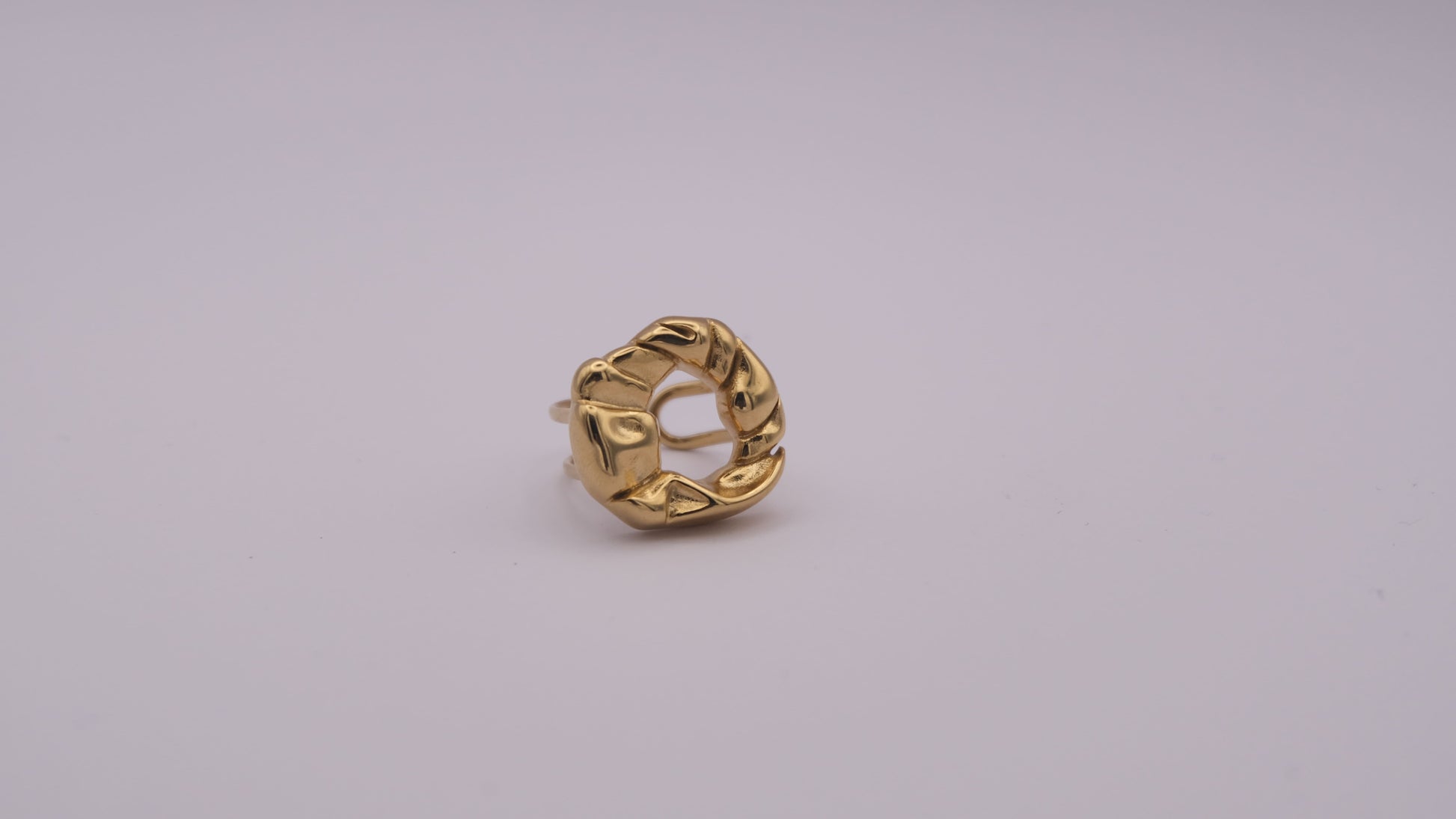 Anillo dorado con textura orgánica "The Cozy Pop" sobre fondo blanco.