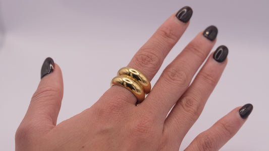 Anillo dorado "The Morning Flow" en la mano de una modelo.