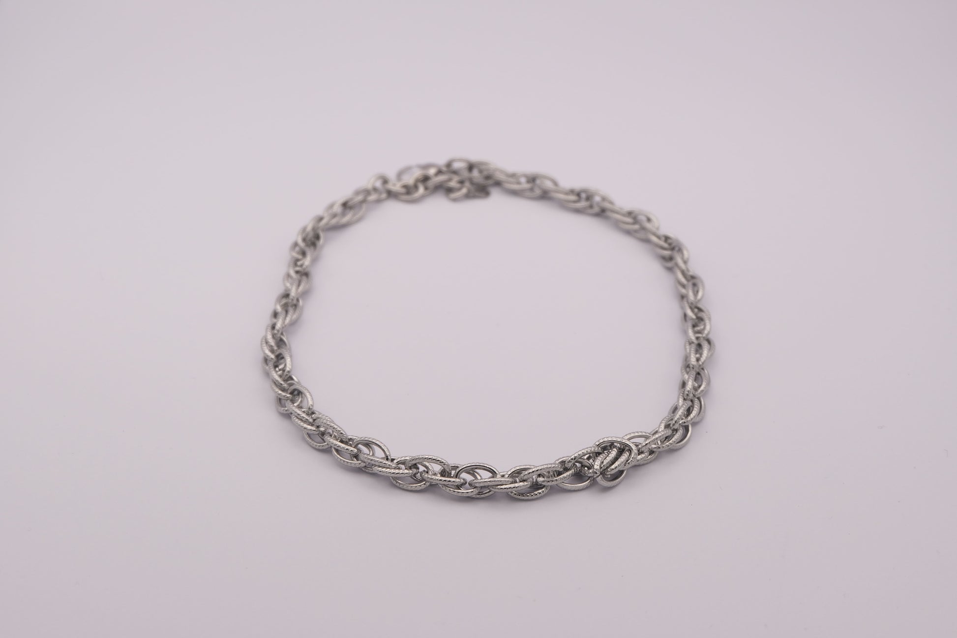Collar de eslabones plateado "The Esencial Link" sobre fondo blanco.