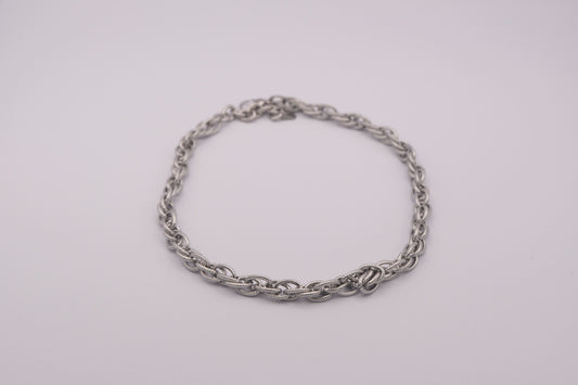 Collar de eslabones plateado "The Esencial Link" sobre fondo blanco.