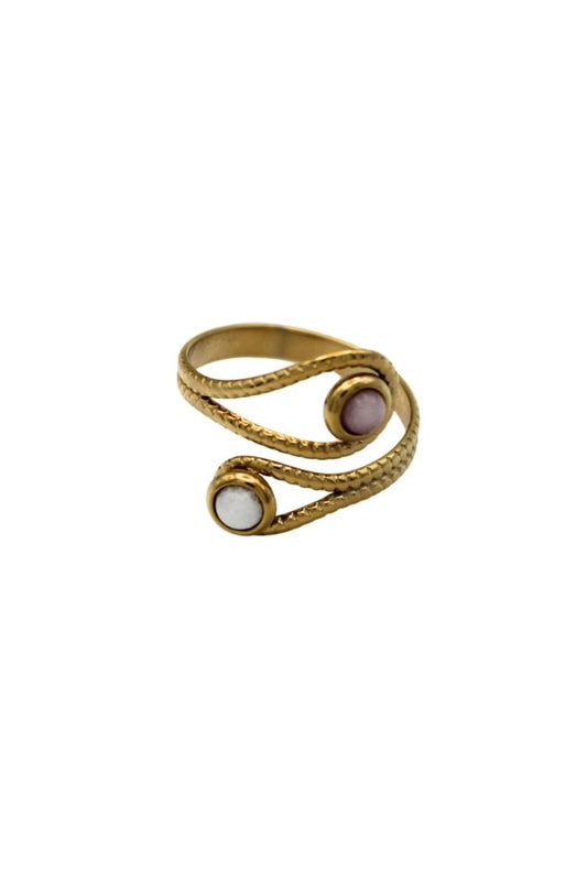 Anillo Cahuita visto desde arriba, con diseño en espiral dorado y dos piedras redondas en blanco y lavanda.
