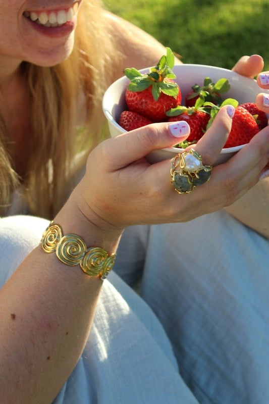 Modelo luciendo el Brazalete Corazón de Guanacaste mientras sostiene un bol de fresas.