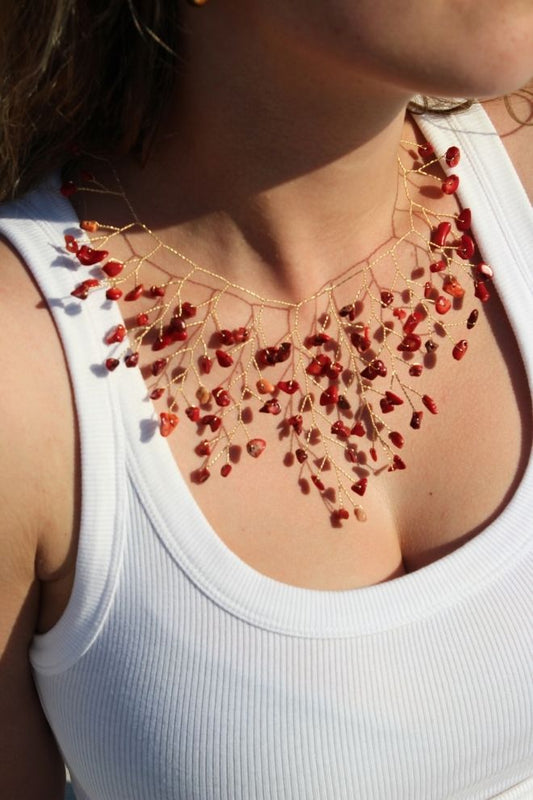Collar Fuego de Arenal lucido sobre el cuello con top blanco
