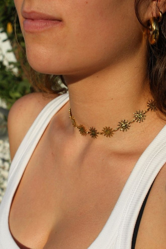 Collar Summer Glow colocado en el cuello, mostrando su ajuste tipo choker y brillo dorado.
