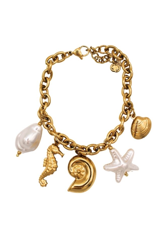 Pulsera Arena y Sol con colgantes marinos y perlas sobre fondo blanco.